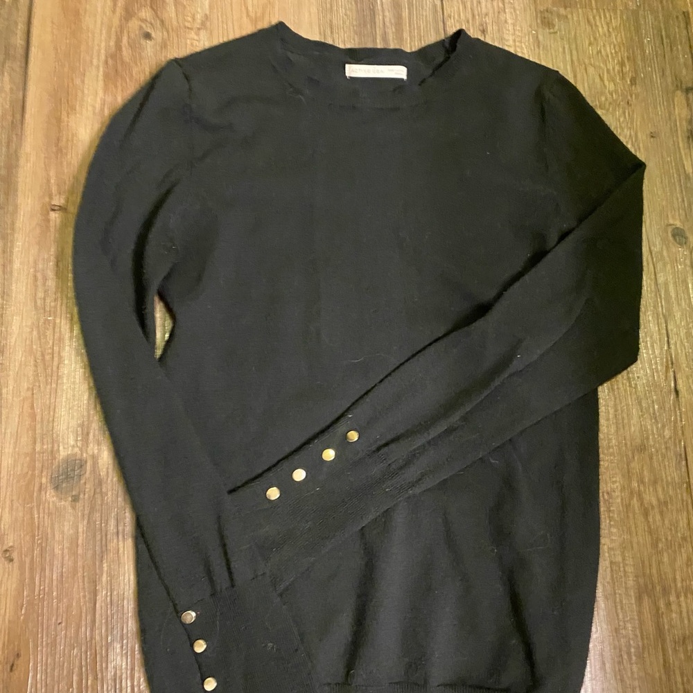 Black sweatery material top with rose
gold button detailing on both sleeves.